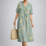 https://cdn.shopify.com/s/files/1/1037/6196/9489/files/polish-model-posed-studio-shot-sage-green-floral-linen-midi-dress-full-body.png?v=1783845542