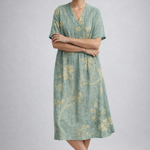 https://cdn.shopify.com/s/files/1/1037/6196/9489/files/sage-green-floral-linen-midi-dress-posed-model-studio-shot-full-body.png?v=1783845542